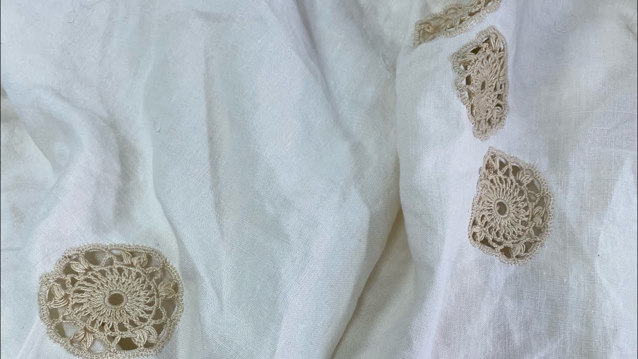 Sulla coperta di lino applichiamo roselline ad  uncinetto.